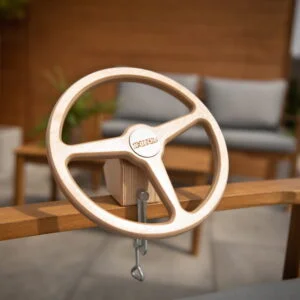 Drewniana zabawkowa kierownica zamontowana na drewnianej ławce w ogrodzie.