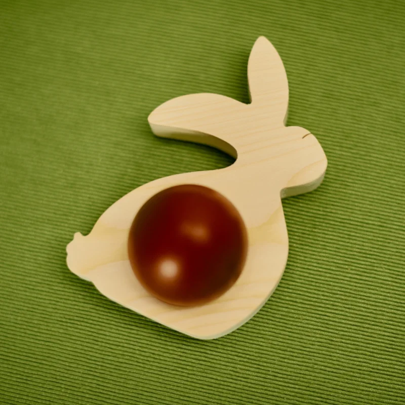 Drewniana ozdoba wielkanocna w kształcie królika z jajkiem.