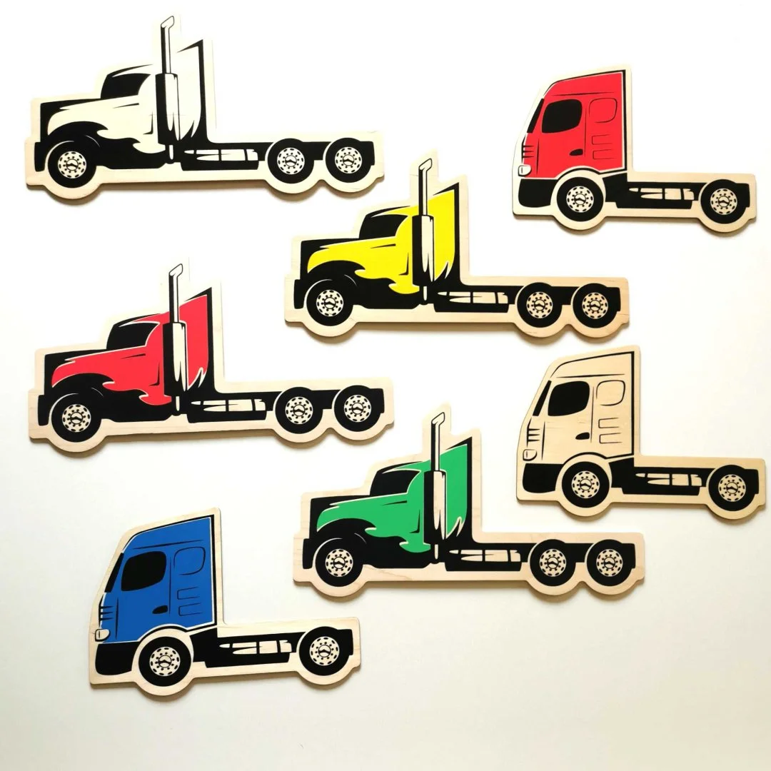 Kolorowe drewniane ciężarówki na białym tle.