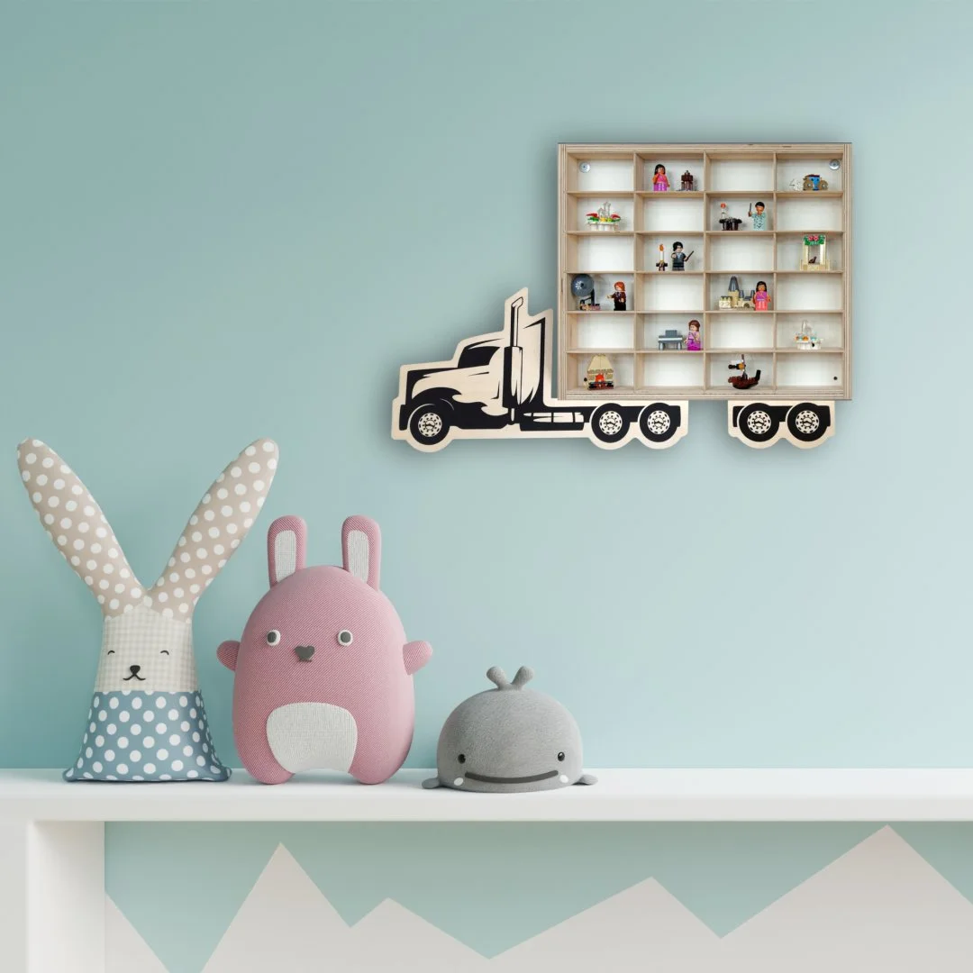 Pokój dziecięcy z półką w kształcie ciężarówki i pluszakami na półce.