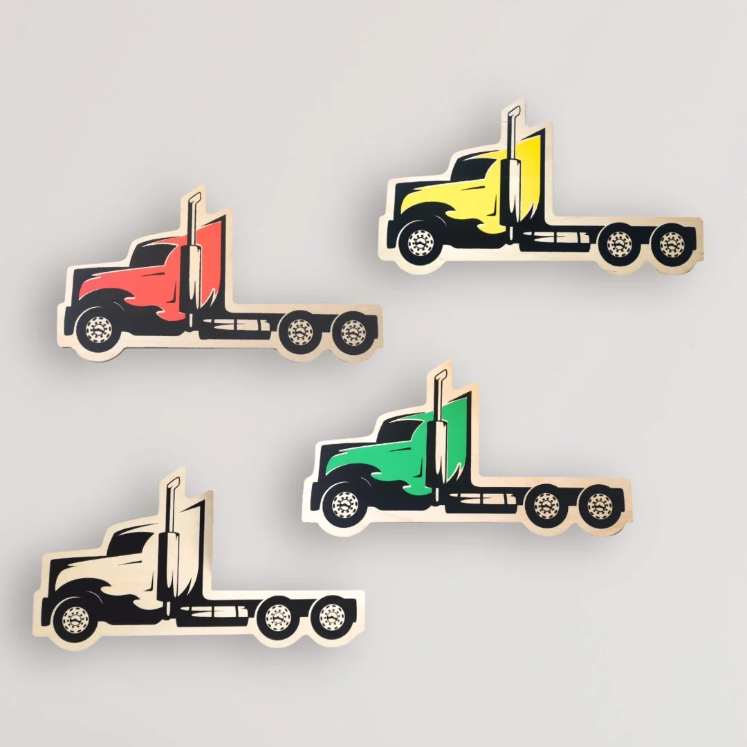 Dekoracyjne naklejki ciężarówek w różnych kolorach na ścianie.