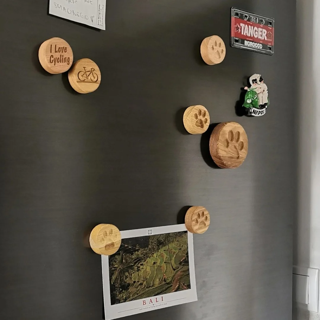 Drewniane magnesy na lodówce z różnymi wzorami.