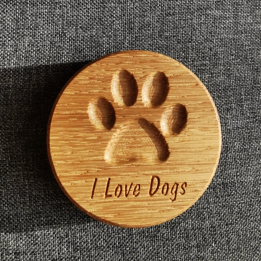Drewniany otwieracz z magnesem z wygrawerowaną łapą psa i napisem I Love Dogs.