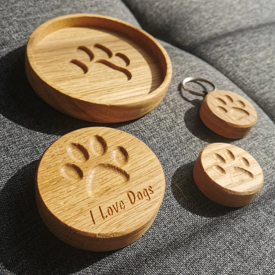 Drewniane akcesoria z wygrawerowanym śladem łapy i napisem 'I Love Dogs'.