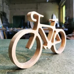 Drewniany model roweru na stole warsztatowym.