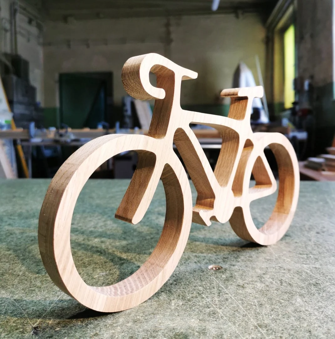 Drewniany model roweru na stole warsztatowym.