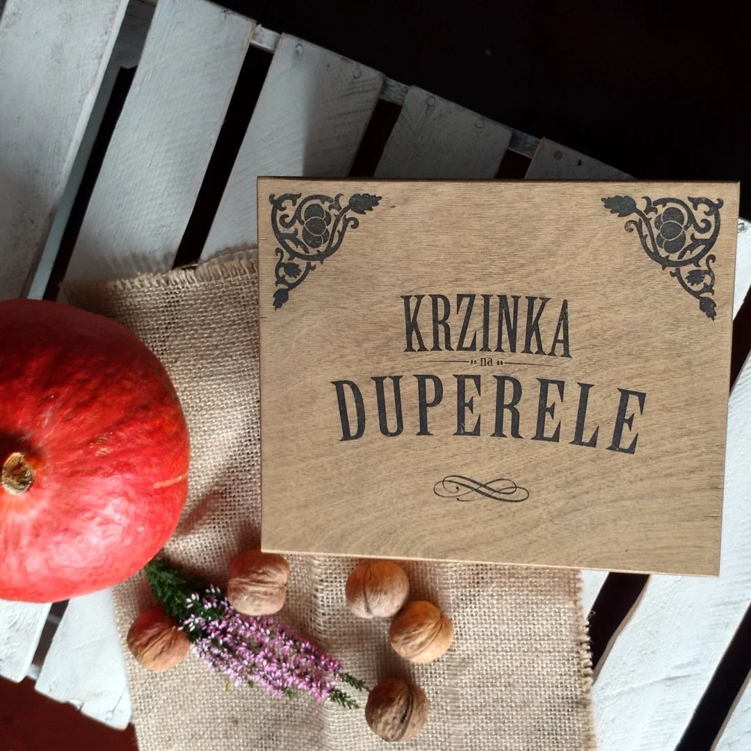 Drewniane pudełko z napisem 'Krzinka na duperele' obok dyni i orzechów.