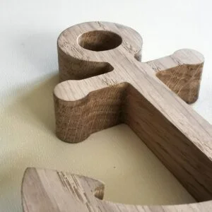 Drewniana dekoracja w kształcie kotwicy na białym tle.