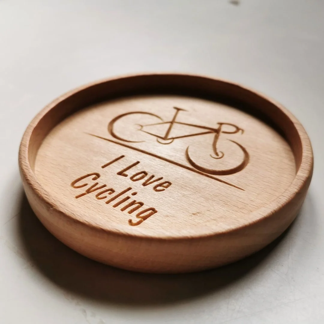 Drewniana podstawka z wygrawerowanym rowerem i napisem I Love Cycling.