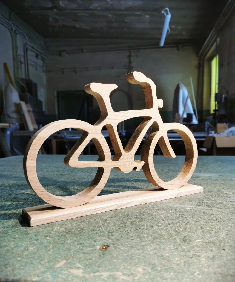 Drewniana figurka roweru na stole warsztatowym.